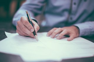 Spenden absetzen Eine männliche Hand schreibt auf einem Papier